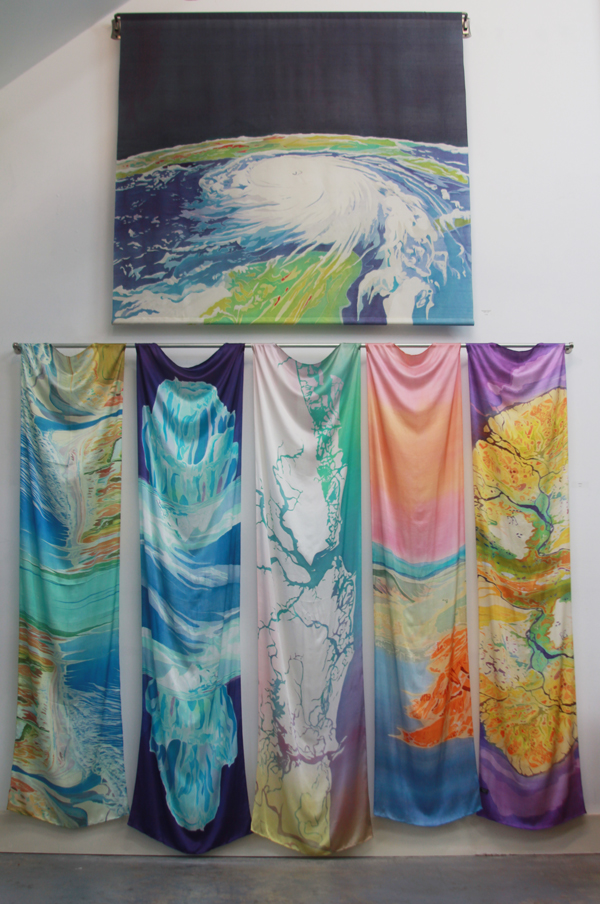 "Hurricane Katrina" batik on silk, hanging on a decorative curtain rod in the studio with silk scarves below